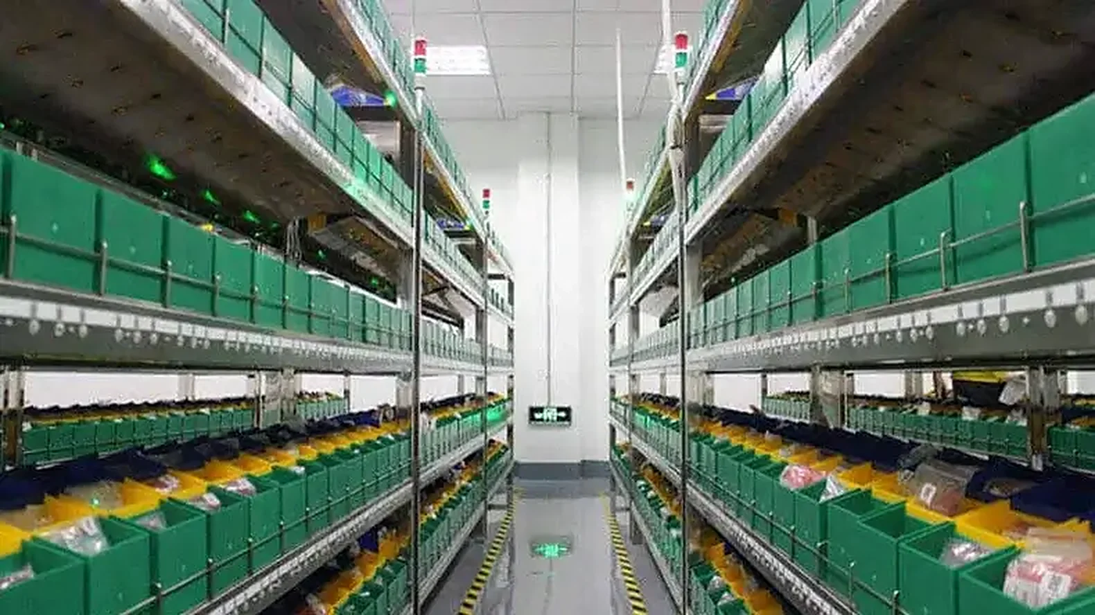 Component store with rows of green bins on shelving racks
